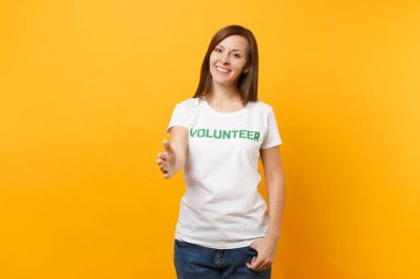 Mutlu gülümseyerek portresi beyaz t-shirt ile yazılı yazıt yeşil başlık gönüllü üzerinde sarı arka plan izole kadın memnun. Gönüllü ücretsiz destek yardım, sadaka grace iş kavramı