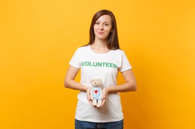 Beyaz kadın portresi t-shirt ile yazılı yazıt yeşil başlık gönüllü oyuncak ayı peluş oyuncak sarı arka plan üzerinde izole tutun. Gönüllü ücretsiz destek yardım, sadaka grace iş kavramı