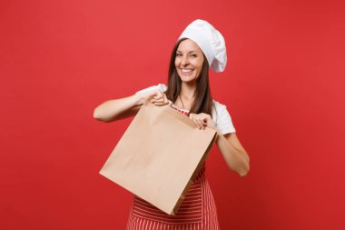 Ev hanımı kadın şef aşçı baker şapkalı izole kırmızı duvar arka plan üzerinde çizgili önlük t-shirt toque şefler. Kadın el kahverengi tutun açık boş el sanatları çanta paket servisi olan restoran sahte kopya alanı kavramı kadar kağıt