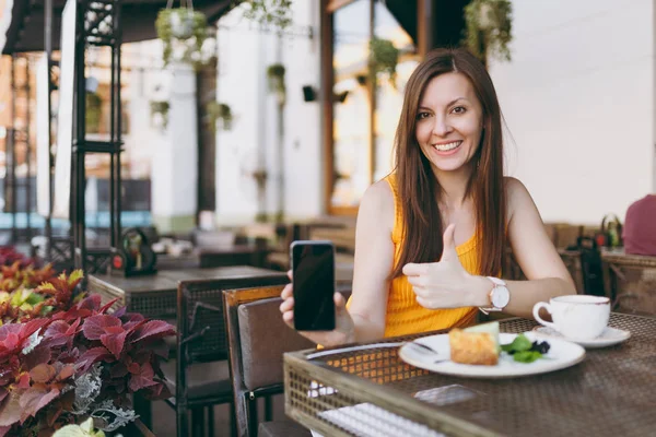 Frau Straßencafé Sitzt Tisch Mit Tee Kuchen Hält Handy Mit — Stockfoto