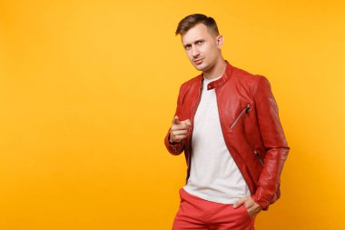 Portre vogue emin yakışıklı genç adam 25-30 yıl içinde kırmızı deri ceket, t-shirt üzerinde izole parlak sarı eğilimleri arka plan ayakta. İnsanlar samimi duygular yaşam tarzı kavramı. Reklam alanı