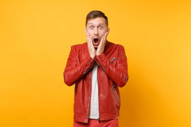 Portre vogue yakışıklı genç adam 25-30 yıl içinde parlak gidişli sarı arka plan üzerinde izole kırmızı deri ceket t-shirt ayakta şok. İnsanlar samimi duygular yaşam tarzı kavramı. Reklam alanı