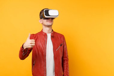 Portre vogue kırmızı deri ceket, t-shirt kulaklık ayakta seyir yakışıklı genç adam parlak sarı eğilimleri arka plan üzerinde izole. İnsanlar samimi duygular yaşam tarzı kavramı. Reklam alanı