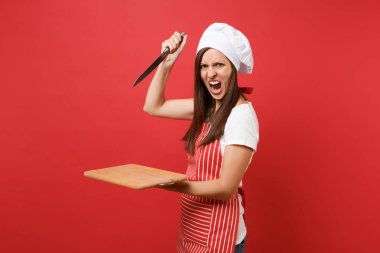 Ev hanımı kadın şef aşçı ya da baker çizgili önlük beyaz t-shirt, toque Şefler Şapka kırmızı duvar arka plan üzerinde izole. Kızgın çığlık atan kadın beklemeye tahta kesme tahtası, bıçak. Kopyalama alanı kavramı alay