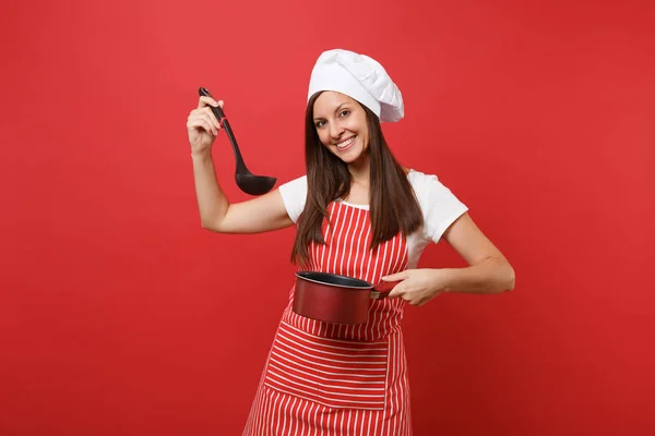 Housewife female chef cook or baker in striped apron white t-shirt toque chefs hat isolated on red wall background. Woman hold tasting empty stewpan black soup ladle dipper Mock up copy space concept