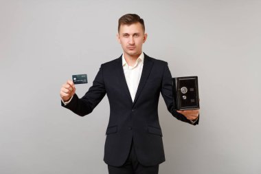 Kredi banka kartı, metal banka gri arka plan üzerinde izole para biriktirme için güvenli tutan Klasik takım elbiseli ciddi genç iş adamı. Başarı kariyer servet iş kavramı. Kopyalama alanı alay