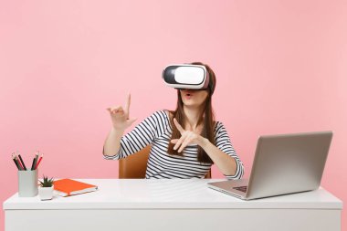 Push düğmesi veya masa başında sanal ekran çalışması yüzen pembe arka plan izole dizüstü bilgisayar ile işaret gibi bir şey baş Touch sanal gerçekliğin kulaklık kız. Başarı iş kariyer
