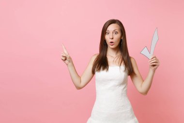 Shocked bride woman in wedding dress pointing index finger aside holding check mark choosing of staff wedding organizers isolated on pink pastel background. Wedding to do list. Celebration concept clipart