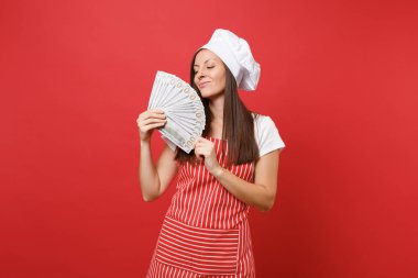 Ev hanımı kadın şef aşçı baker izole kırmızı duvar arka plan üzerinde çizgili önlük, beyaz tişört, toque şefler şapkalı. Dolar banknot bir sürü nakit para tutan mutlu kadın. Kopyalama alanı kavramı alay