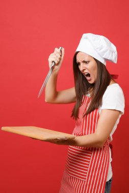 Ev hanımı kadın şef aşçı ya da baker çizgili önlük beyaz t-shirt, toque Şefler Şapka kırmızı duvar arka plan üzerinde izole. Kızgın çığlık atan kadın beklemeye tahta kesme tahtası, bıçak. Kopyalama alanı kavramı alay