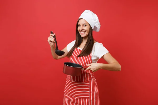 Housewife female chef cook or baker in striped apron white t-shirt toque chefs hat isolated on red wall background. Woman hold tasting empty stewpan black soup ladle dipper Mock up copy space concept
