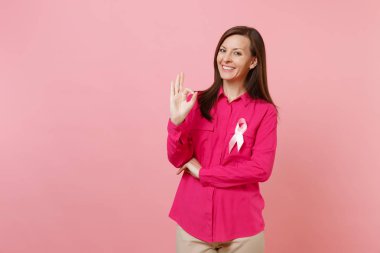 Pastel duvar arka planda, stüdyo portre izole pembe ipek kurdele simgesi olan gül giysili bir kadın. Tıbbi sağlık Jinekolojik Onkoloji, meme kanseri bilinçlendirme kavramı. Kopyalama alanı alay