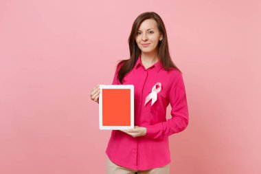 Pastel duvar arka planda, stüdyo portre izole pembe ipek kurdele tutun tablet pc ile gül giysili bir kadın. Tıbbi sağlık Jinekolojik Onkoloji, meme kanseri bilinçlendirme kavramı sahte alanı