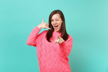 Telefon jest gibi yapıyor pembe kazaklı genç kadın bana geri, işaret parmağı yanıp sönen izole çağrı mavi duvar arka plan üzerinde diyor. İnsanlar samimi duygular, yaşam kavramı. Kopyalama alanı alay