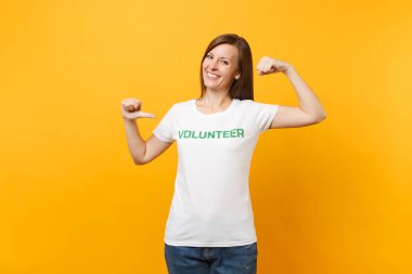 Mutlu gülümseyerek portresi beyaz t-shirt ile yazılı yazıt yeşil başlık gönüllü üzerinde sarı arka plan izole kadın memnun. Gönüllü ücretsiz destek yardım, sadaka grace iş kavramı