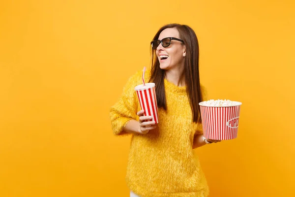 Neşeli genç kadın arayan bir kenara izlerken film film tutun kova patlamış mısır, plastik bardak kola veya izole sarı zemin üzerine soda 3d IMAX bardaklarda. İnsanlar sinema, samimi duygular yaşam tarzı