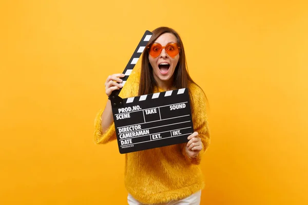 兴奋搞笑的年轻女子穿着皮草毛衣和橙色的心眼镜拿着经典的黑胶卷 在黄色背景上孤立的隔板 人们真诚的情感 生活方式 广告区 — 图库照片