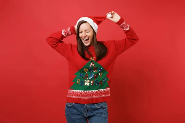 赤い壁の背景に分離されたクリスマスの帽子に手を維持するニットのセーターに目を閉じて笑っている若いサンタ女の子 幸せな新しい年 2019年お祝いの休日党の概念 コピー スペースをモックアップします — ストック写真