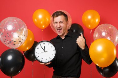 Kazanan, kırmızı arka plan hava balonu üzerinde yuvarlak saat holding gibi yumruk kenetlenmesi siyah klasik gömlek mutlu genç adam. Dünya Kadınlar günü, mutlu yeni yıl, Doğum günü mockup tatil parti konsept