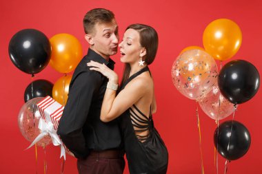 Hediye kutusu kutluyor Doğum günü tatil partisi parlak kırmızı arka plan hava balonu üzerinde izole St. Valentine Uluslararası Kadınlar Günü mutlu yeni yıl 2019 kavramı siyah giysili genç çift tutun.