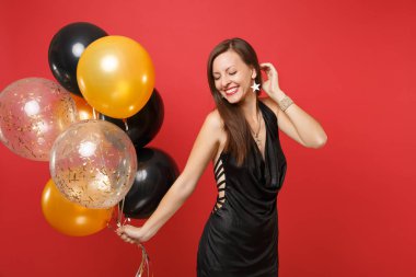 Kapalı gözlü küçük siyah elbise kutlayarak parlak kırmızı zemin üzerine izole hava balonları tutan genç kız çarpıcı. St. Valentine's gün Happy New Year Doğum günü mockup tatil parti konsept