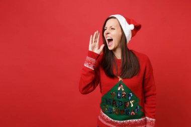 Örme kazak, Noel şapka el hareketi ile çığlık çılgın genç Noel Baba kız parlak kırmızı duvar arka plan üzerinde izole. Mutlu yeni yıl 2019 kutlama tatil parti kavramı. Kopyalama alanı alay