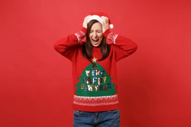 Hayal kırıklığına uğramış kızgın Santa kızla kırmızı zemin üzerine izole çığlık çığlık putting eller baş, baş ağrısı olan gözler kapalı. Mutlu yeni yıl 2019 kutlama tatil parti kavramı. Kopyalama alanı alay