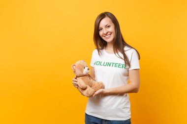 Beyaz kadın portresi t-shirt ile yazılı yazıt yeşil başlık gönüllü oyuncak ayı peluş oyuncak sarı arka plan üzerinde izole tutun. Gönüllü ücretsiz destek yardım, sadaka grace iş kavramı