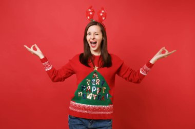 Yanıp sönen, dekoratif geyik boynuzları tutma ağız geniş açık, eğlenceli neşeli Noel Baba kız Yayilim eller kırmızı zemin üzerine izole meditasyon. Mutlu yeni yıl 2019 kutlama tatil parti konsept