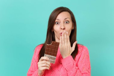 Palm ile ağız kapsayan örme pembe kazaklı hayran genç kadın elinde çikolata izole mavi turkuaz duvar arka plan stüdyo portre üzerinde tutun. İnsanlar yaşam tarzı kavramı. Kopyalama alanı alay
