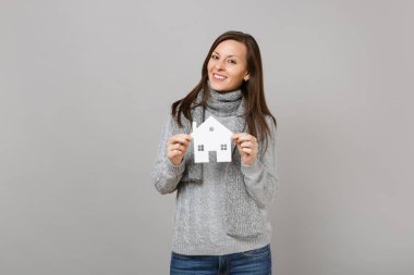 Gülümseyen gri süveterli genç kadın, Studio gri arka plan üzerinde Beyaz Saray izole holding kağıt eşarp. Sağlıklı moda yaşam tarzı, insanlar samimi duygular, soğuk sezon kavramı. Kopyalama alanı alay