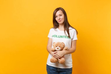 Beyaz kadın portresi t-shirt ile yazılı yazıt yeşil başlık gönüllü oyuncak ayı peluş oyuncak sarı arka plan üzerinde izole tutun. Gönüllü ücretsiz destek yardım, sadaka grace iş kavramı