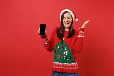 Mutlu Noel Baba kız gözlerini tutmak ile izole kırmızı zemin üzerine boş boş perde hareket eden telefon holding Yayilim eller kapalı. Mutlu yeni yıl 2019 kutlama tatil parti kavramı. Kopyalama alanı alay