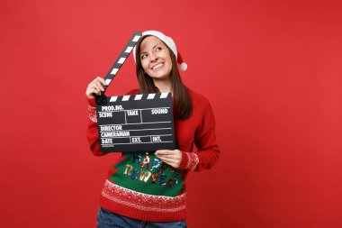 Noel şapkalı bakılması, rüya gibi genç Noel Baba kız kırmızı zemin üzerine izole Klaket yapma klasik kara film tutun. Mutlu yeni yıl 2019 kutlama tatil parti kavramı. Kopyalama alanı alay