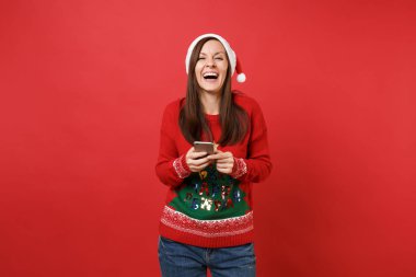 Noel Baba kız örme kazak gülüyor, cep telefonunuzun sms mesajı yazarak Noel şapka kırmızı zemin üzerine izole. Mutlu yeni yıl 2019 kutlama tatil parti kavramı. Kopyalama alanı alay