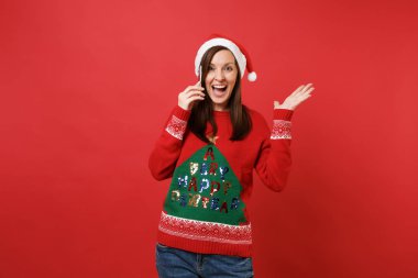 Cep telefonu üzerinde konuşurken el yayılan genç Noel Baba kız hoş sohbet izole kırmızı zemin üzerine iletken hayran. Mutlu yeni yıl 2019 kutlama tatil parti kavramı. Kopyalama alanı alay