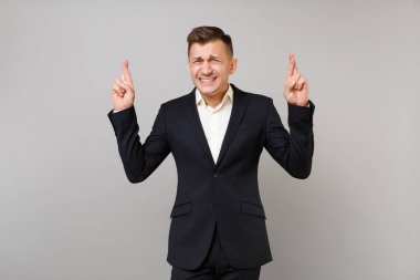 Studio gri arka plan üzerinde izole bir an için bekleyen anticipant genç iş adamı Klasik takım parmak tutmak geçti. Başarı kariyer servet iş kavramı. Kopyalama alanı alay