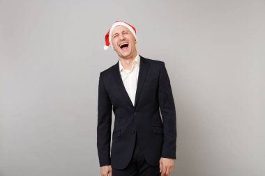 Noel şapka Studio gri duvar arka plan üzerinde izole klasik siyah elbiseli Genç iş adamı gülüyor. Başarı kariyer servet iş. Mutlu yeni yıl 2019 kutlama tatil parti konsept
