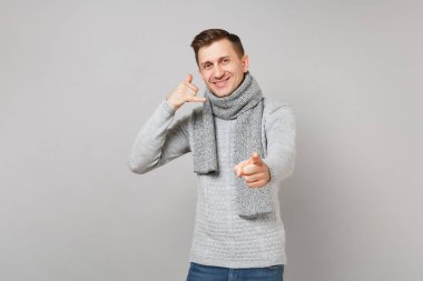 Yakışıklı erkek kazak, beni ara, işaret parmağı gri arka plan üzerinde izole kamera eşarp gibi telefon jest yapıyor diyor. Sağlıklı yaşam, insanlar samimi duygular, soğuk sezon kavramı