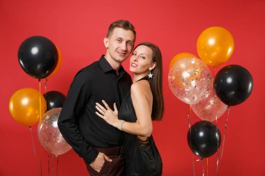 Parlak kırmızı arka plan hava balonu üzerinde kutluyor Doğum günü tatil partisi izole siyah giysili genç çift çarpıcı. St. Valentine's Dünya Kadınlar Günü mutlu yeni yıl 2019 kavramı.