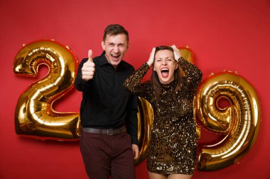 Kaç adam kız parlak parlak elbise, siyah gömlek parlak kırmızı duvar arka plan golden numaraları hava balonları stüdyo portre üzerinde izole tatil partisi kutluyor. Mutlu yeni yıl 2019 Noel kavramı