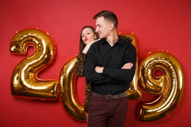 Kaç adam kız parlak parlak elbise, siyah gömlek parlak kırmızı duvar arka plan golden numaraları hava balonları stüdyo portre üzerinde izole tatil partisi kutluyor. Mutlu yeni yıl 2019 Noel kavramı