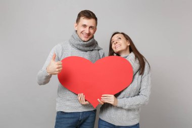 Sevimli Genç kız adam gri kazak, eşarplar birlikte gri duvar arka planda, stüdyo portre izole çift. Sağlıklı yaşam tarzı, hasta hasta hastalık tedavileri, soğuk sezon kavramı. Kopyalama alanı alay