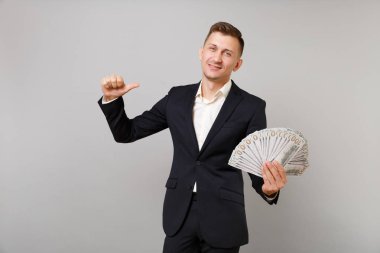 Dolar banknotlar demet çok nakit para üzerinde gri arka plan izole tutarak kendini başarılı genç iş adam işaret parmağı. Başarı kariyer servet iş kavramı. Kopyalama alanı alay