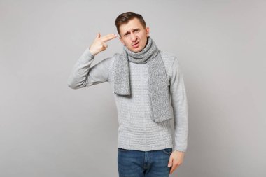 Gri kazak, sanki o ateş kendisi hakkında gri arka plan üzerinde izole kafa eşarp noktası parmak umutsuz genç adam. Sağlıklı yaşam, insanların duygu, soğuk sezon kavramı. Kopyalama alanı alay