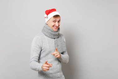 Neşeli Noel Baba adam gri süveterli Noel şapka işaret parmağı Studio gri arka plan üzerinde izole kamera eşarp. Mutlu yeni yıl 2019 kutlama tatil parti kavramı. Kopyalama alanı alay