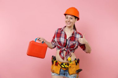 Güçlü genç tamirci kadın portakal kask, ekose gömlek, kot şort, aletleri, dolu, pembe arka plan izole araç seti araçları kemer. Kadın erkek iş. Yenileme işgal kavramı
