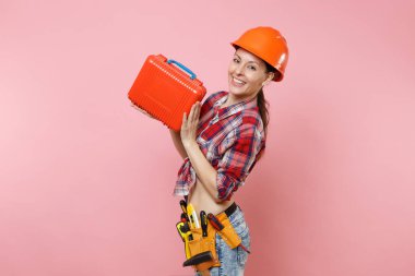 Güçlü genç tamirci kadın portakal kask, ekose gömlek, kot şort, aletleri, dolu, pembe arka plan izole araç seti araçları kemer. Kadın erkek iş. Yenileme işgal kavramı