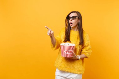 3d IMAX bardaklarda işaret parmağı kova patlamış mısır tutun film film izlerken şok korkmuş bir genç kız parlak sarı arka plan üzerinde izole. Sinema yaşam tarzı kavramı insanların samimi duygular