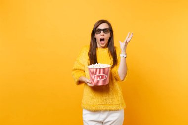 Şok korkmuş genç kız çığlık, eller yayılan, parlak sarı arka plan üzerinde izole patlamış mısır tutarak film film izlerken 3d IMAX gözlük. Sinema, yaşam kavramı insanların samimi duygular